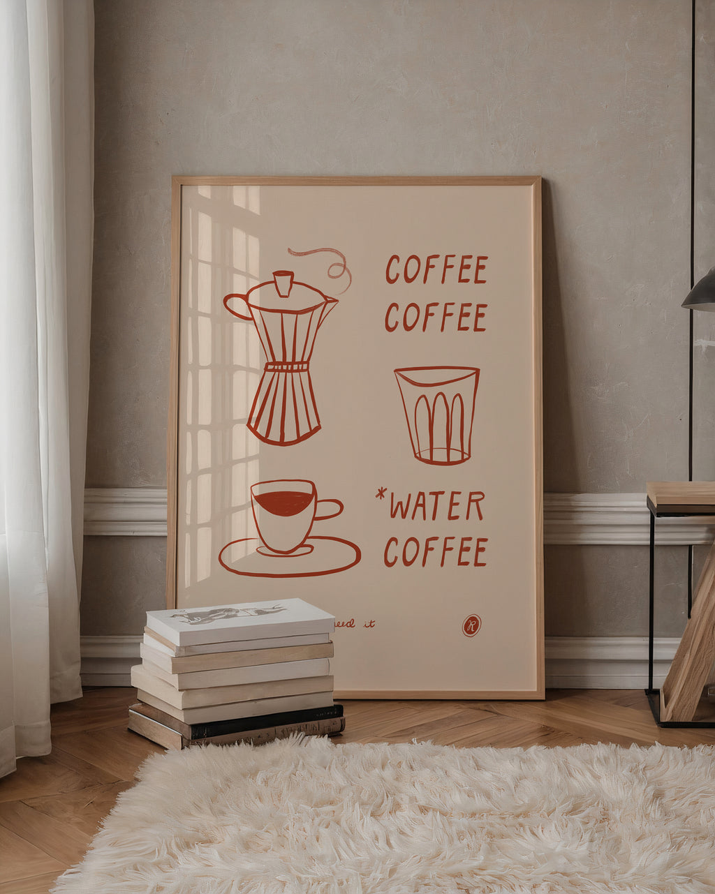 A framed minimalist coffee-themed art print leaning against a beige wall in a styled room. The print features red line drawings of a moka pot, a glass, a cup, and the words 'COFFEE' and '*WATER COFFEE' on a cream background.